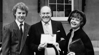 English actor Timothy West, holding his CBE, with his wife Prunella Scales and their son, British actor Samuel West, London, UK, 4th December 1984.