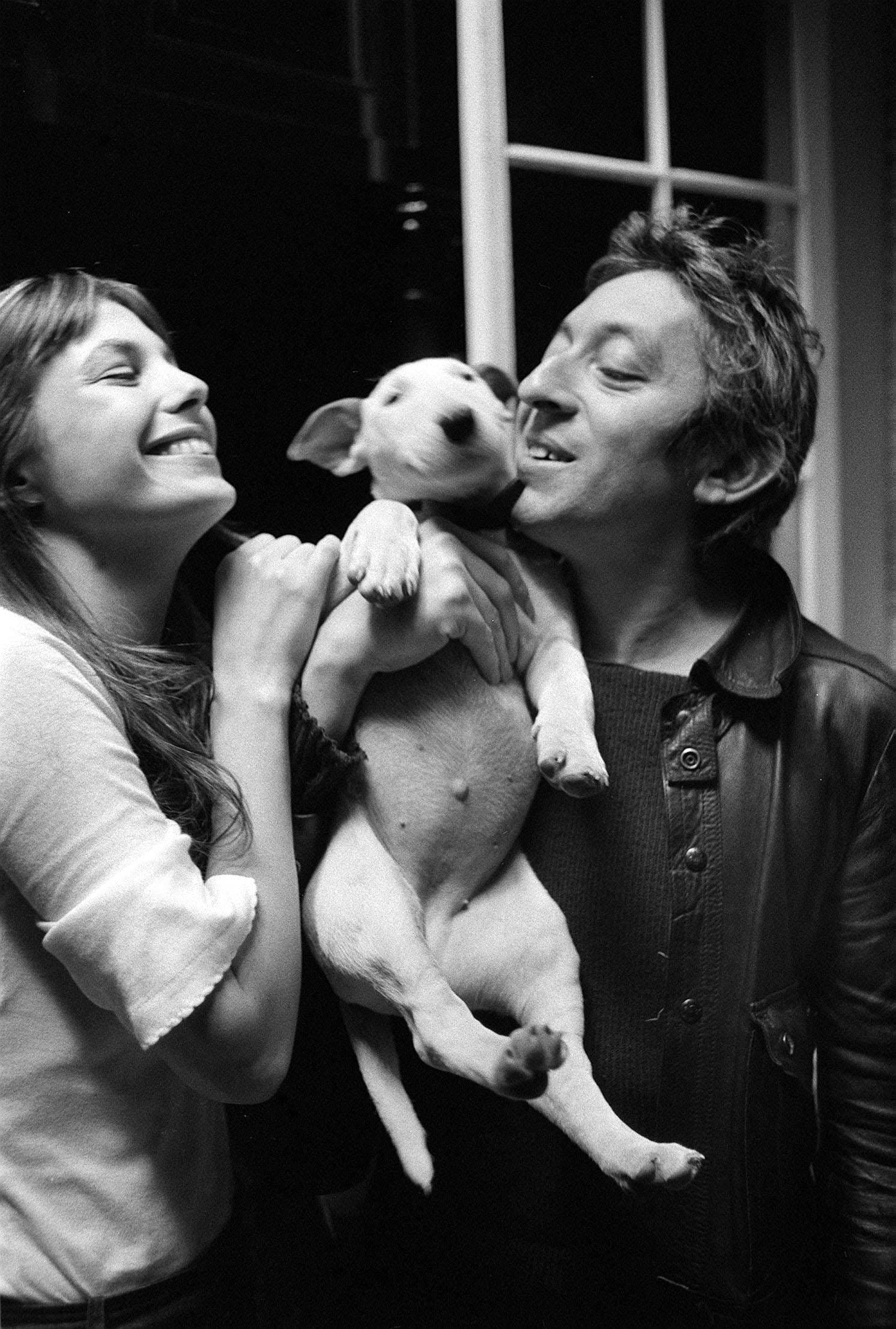 Jane Birkin and Serge Gainsbourg cuddling an English bull terrier