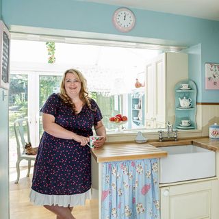 lady standing in blue wall kitchen