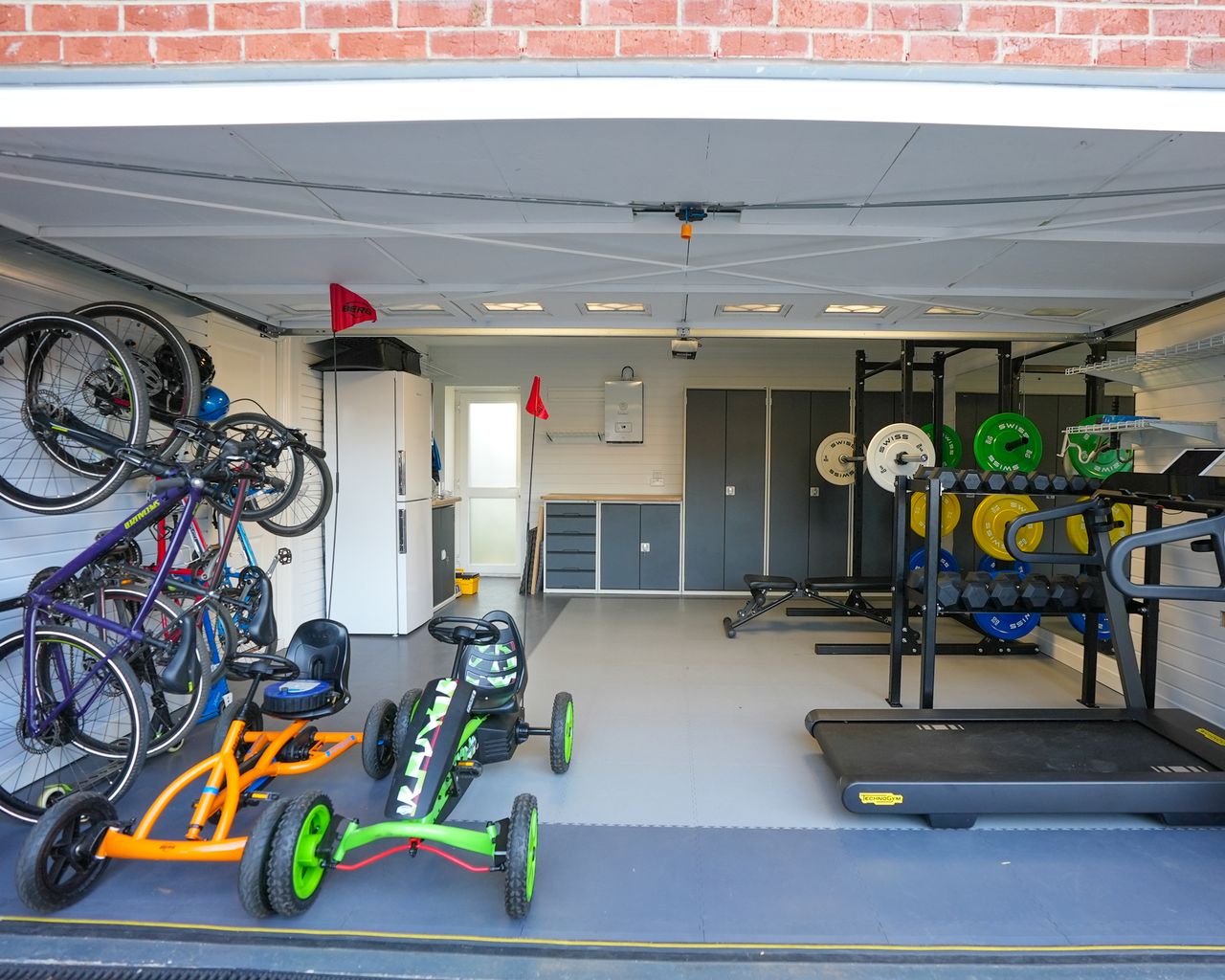 Home gym in garage with storage lockers and bikes