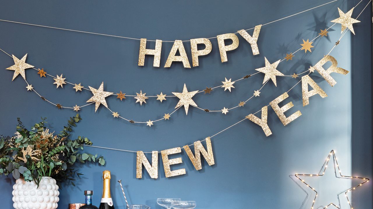 Blue wall with gold happy new year banner strung across it