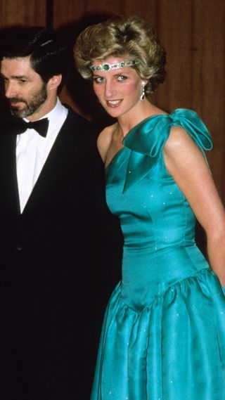 Diana, Princess of Wales, wearing a green satin evening dress designed by David and Elizabeth Emanuel and an emerald necklace as a headband, attend a gala dinner dance at the Southern Cross Hotel