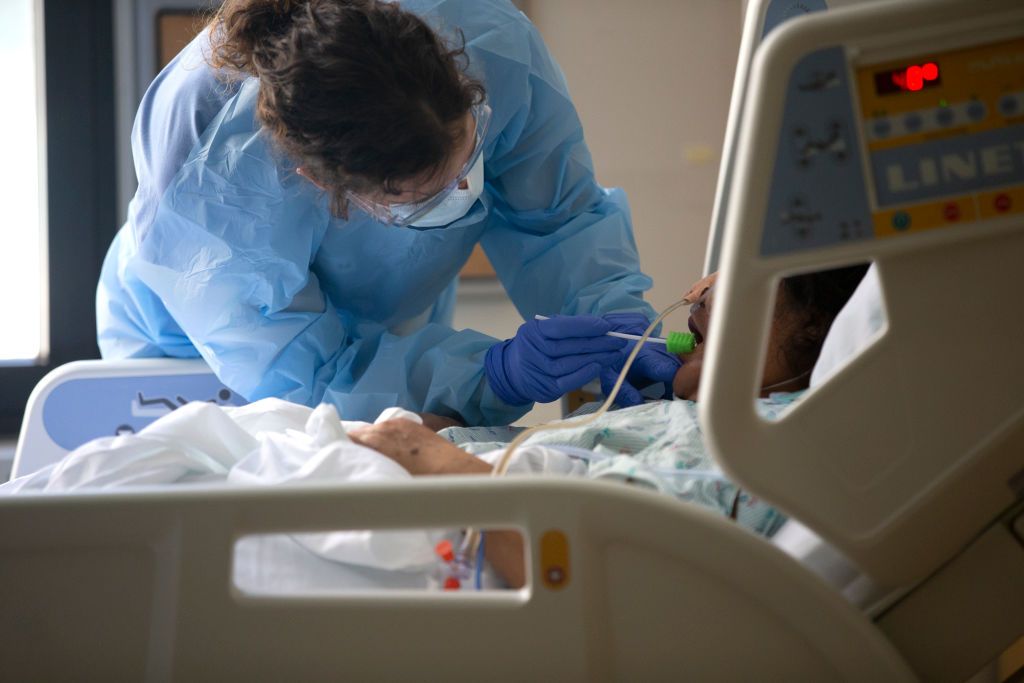 Nurse Karen Hayes uses an oral hygiene tool to administer care to a patient in the acute care COVID unit at Harborview Medical Center on May 7, 2020 in Seattle, Washington.