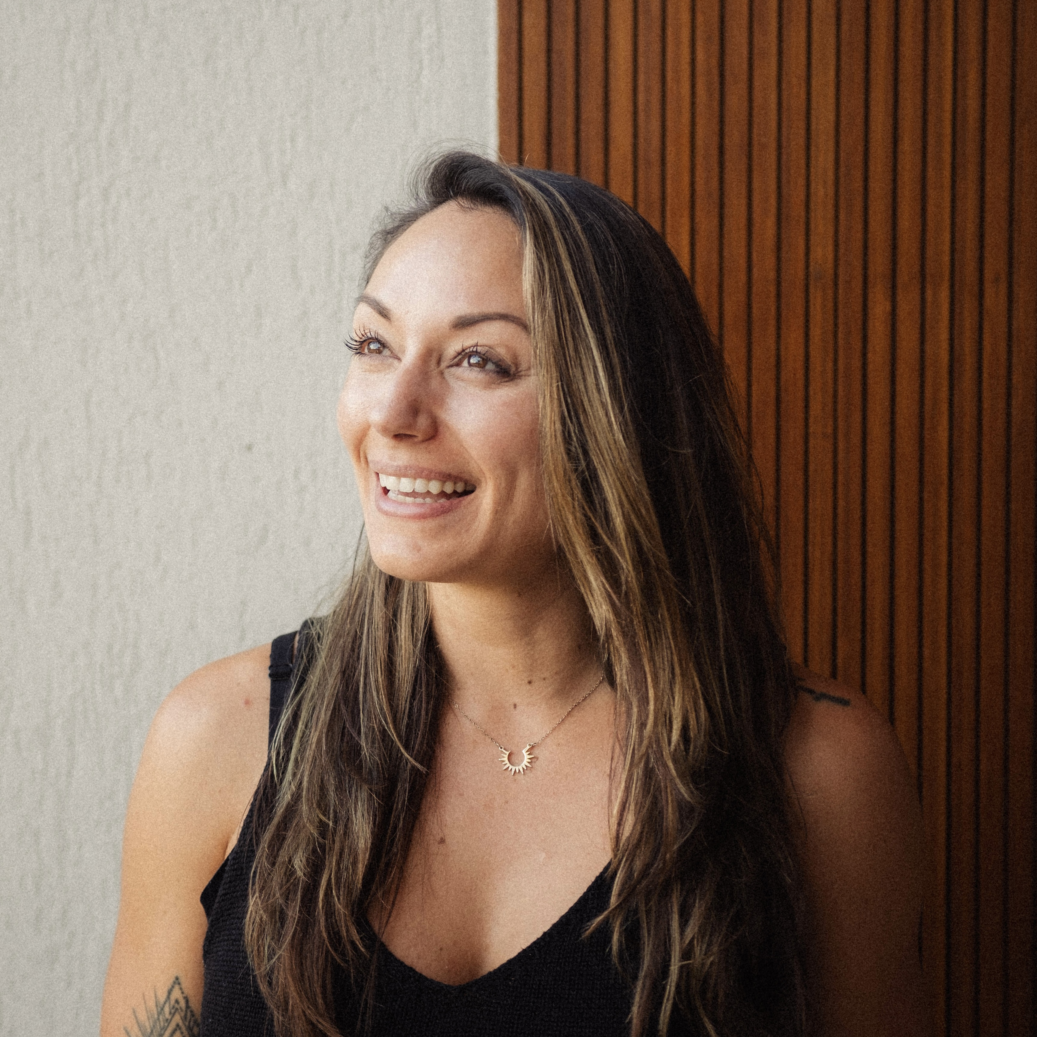 Head and shoulders of smiling woman, wearing black tank top