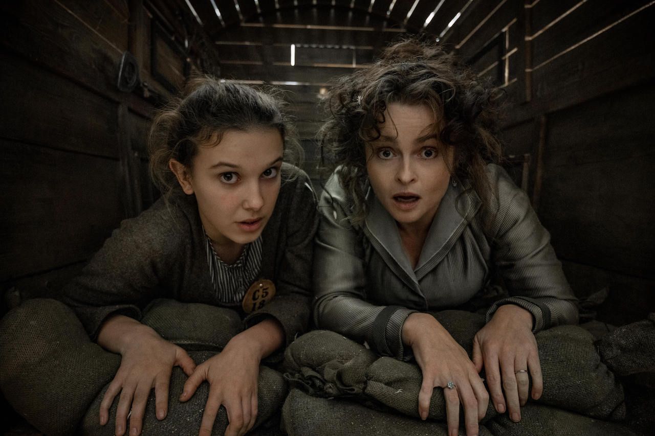 Millie Bobby Brown and Helena Bonham Carter closely cramped next to each other in Enola Holmes 2