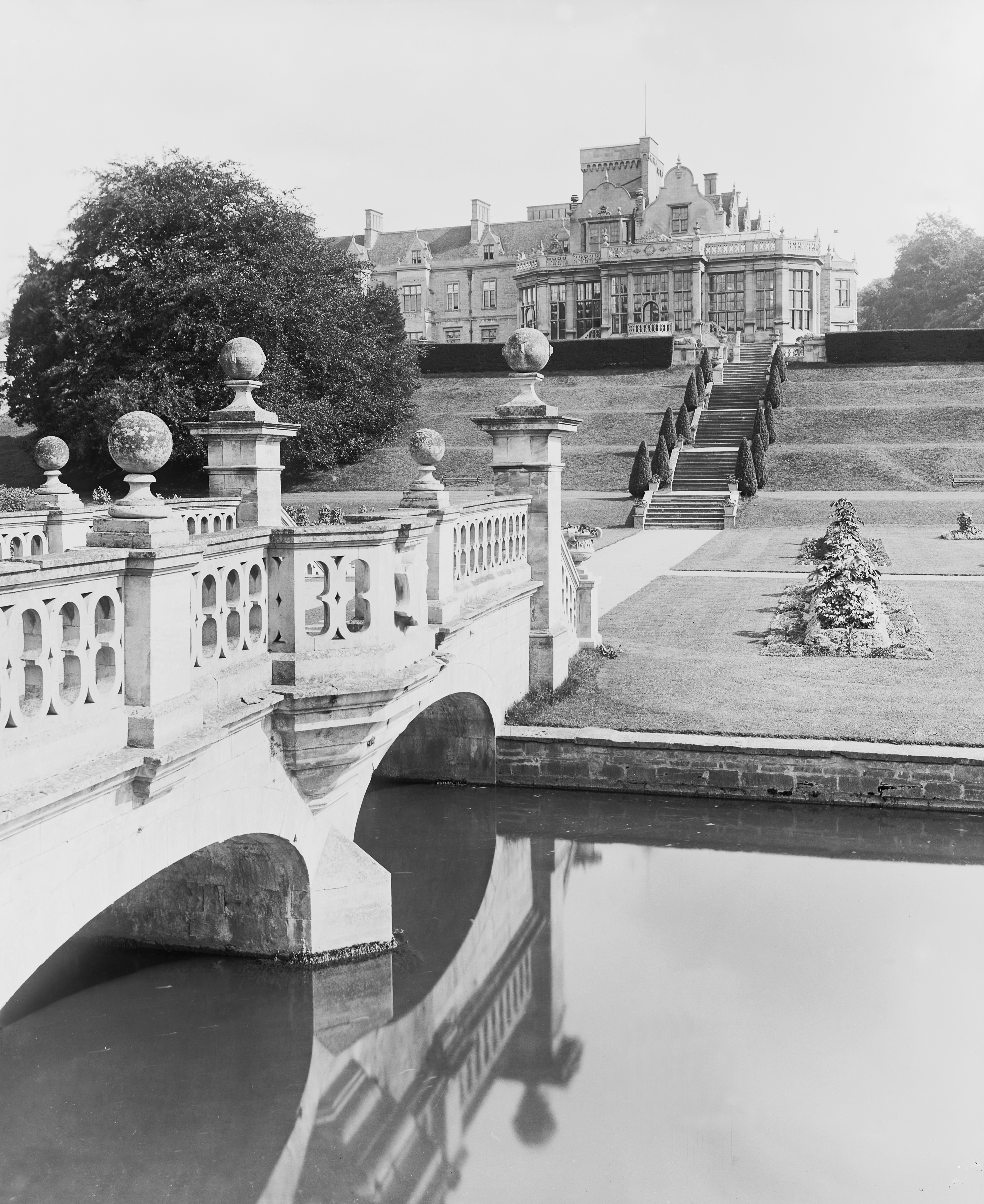 Large home with a moat and bridge in front of it