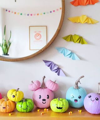 DIY Halloween decorations using home grown pumpkins hand painted with expressions with mirror, candy corn and origami bats