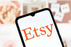 Etsy logo on a smartphone with vision board blurred in the background