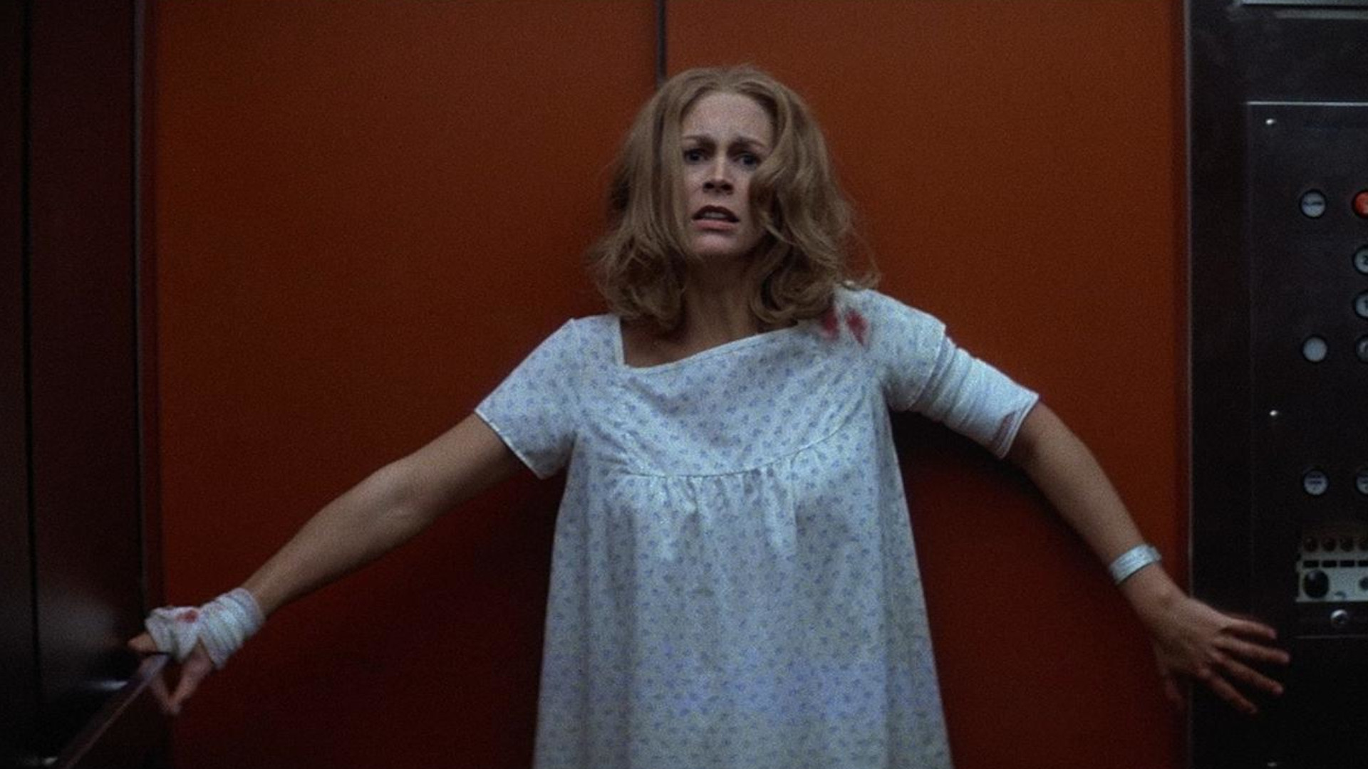 Jamie Lee Curtis as Laurie Strode wearing a hospital gown and looking scared during Halloween 2