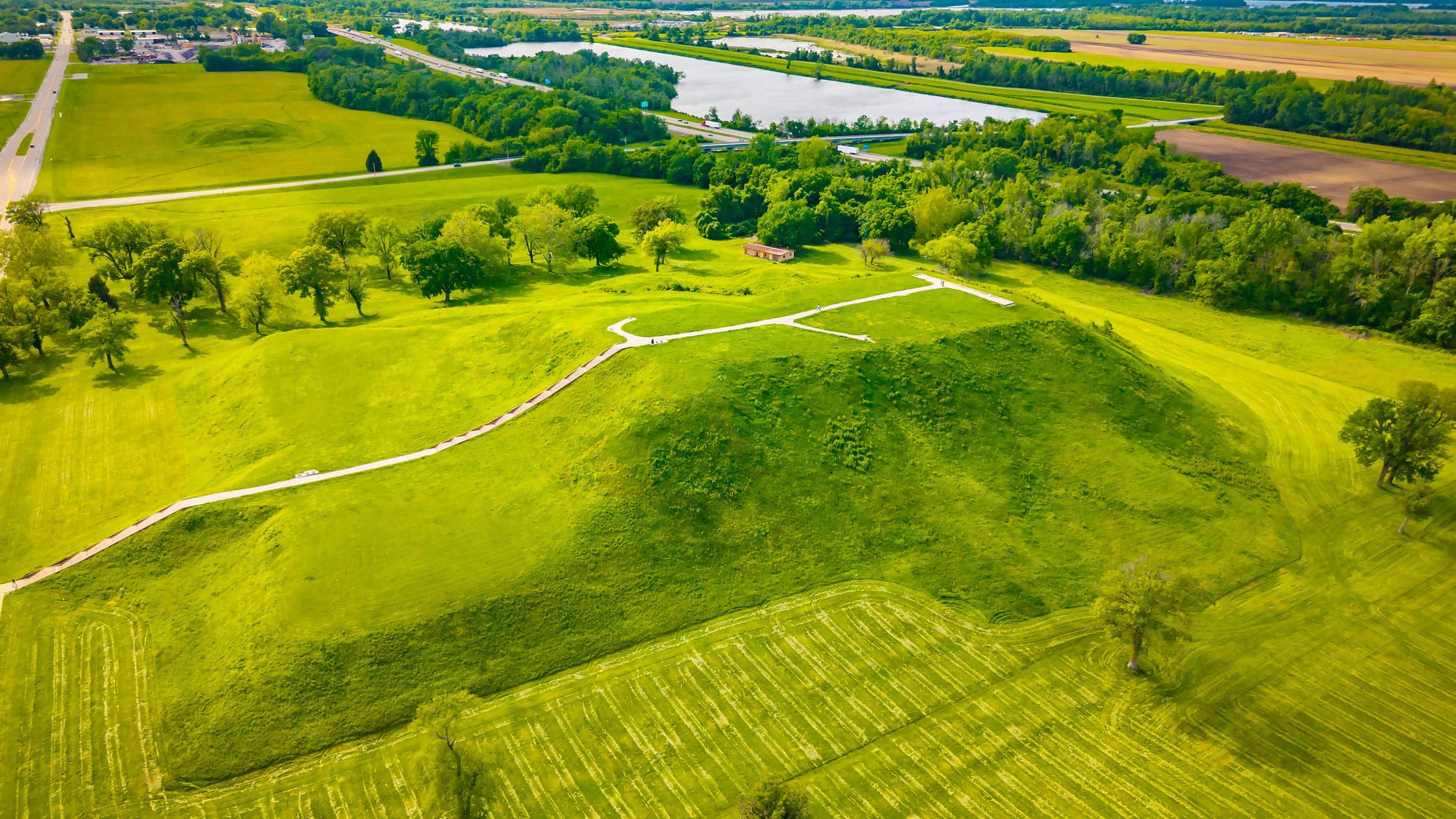 An aerial view of an archaeological site covered in green grass.