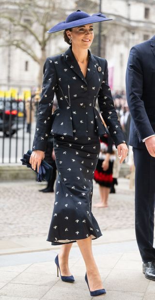 Kate Middleton wearing a navy skirt suit and blazer walking into Westminster Abbey