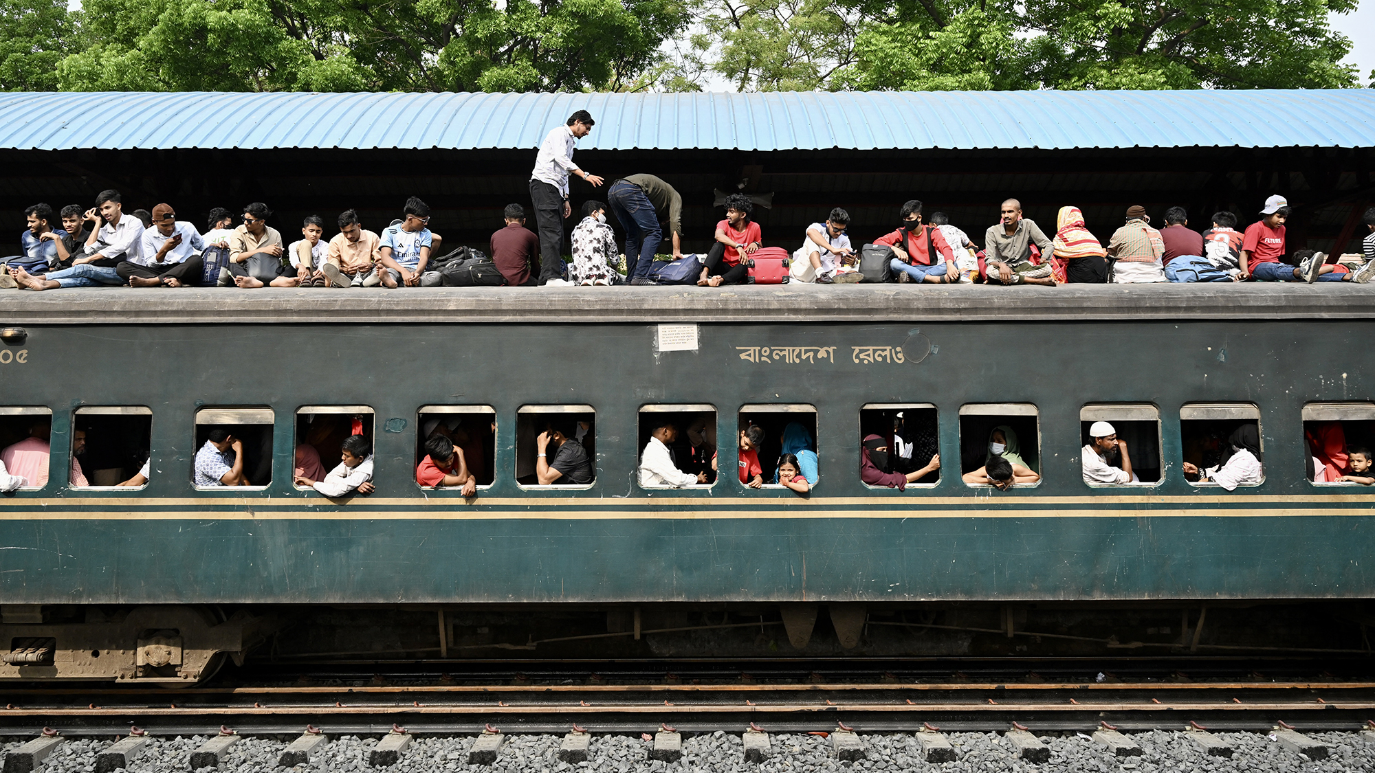 People clamber onto the roof of a crowded train ahead of the Muslim festival of Eid al-Fitr in Tongi, Bangladesh