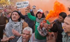 Anti-Morsi protesters shout slogans in front of the presidential palace in Cairo, Feb. 1.