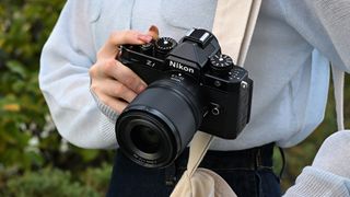 Nikon Nikkor Z 35mm f/1.4 lens mounted to a Nikon Zf, being held by a photographer
