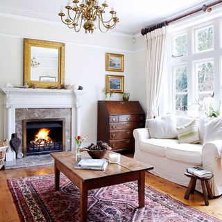 living area with white wall and fireplace and wooden floor and white sofa