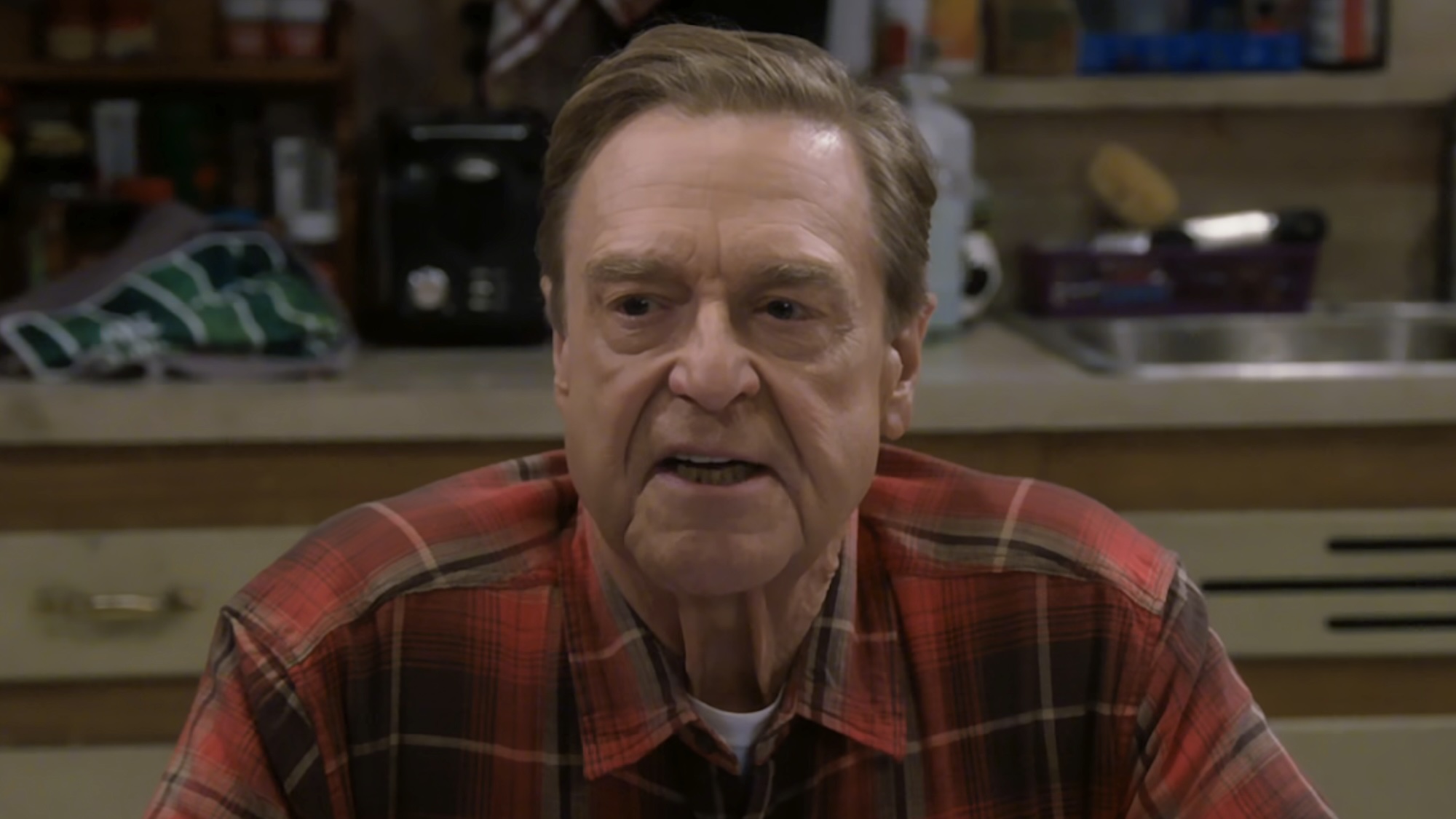 Dan Conner sitting at kitchen table talking to Darlene and Ben in The Conners Season 6