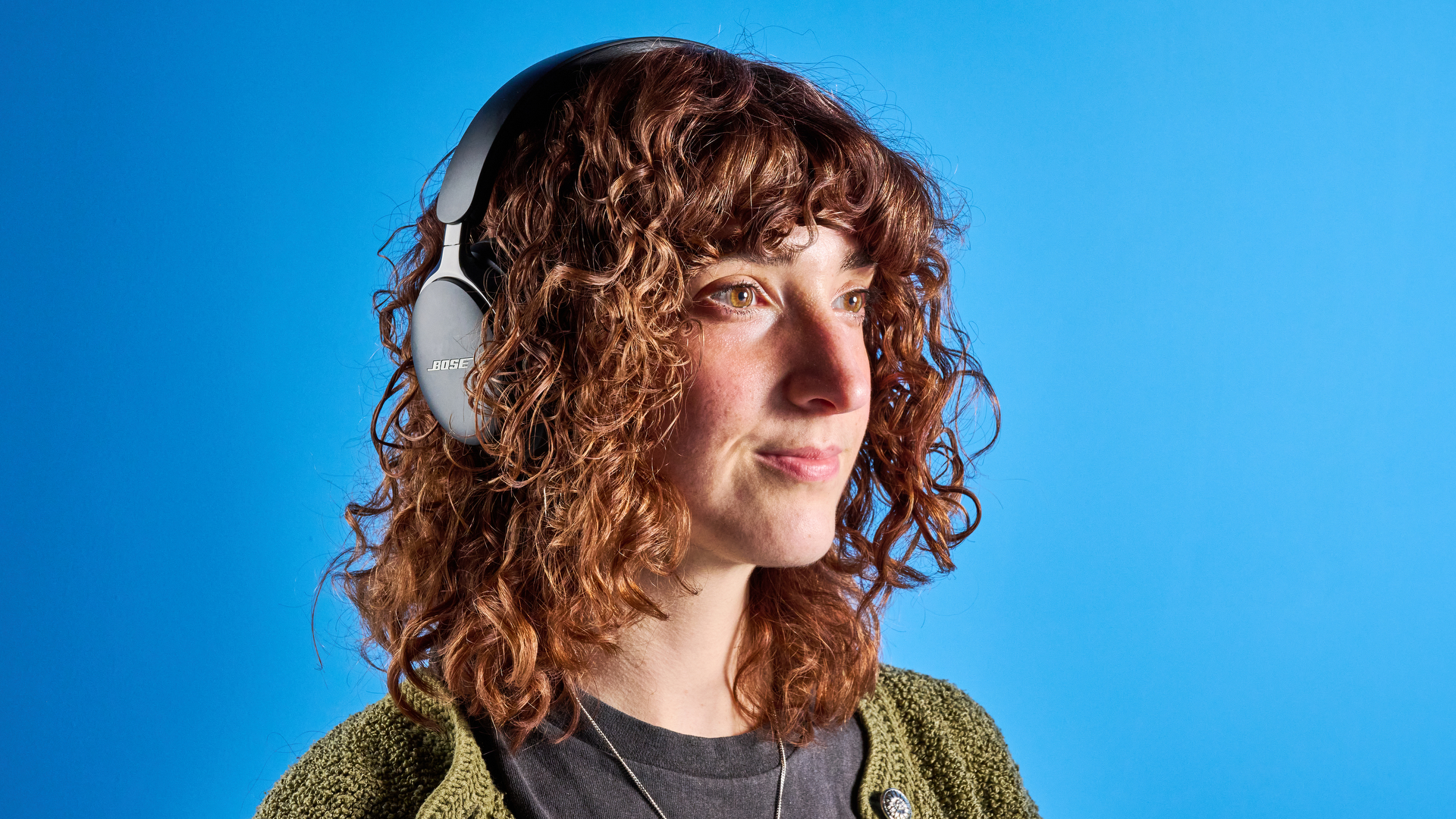 the bose quietcomfort ultra gen 2 headphones in black photographed on a blue tom's guide background