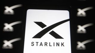 Close up of the Starlink logo, a stylised black 'X' with the word starlink beneath on a white background, with other such logos in the background but blurry