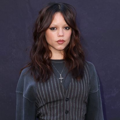 Jenna Ortega attended a Wednesday event in a pinstripe suit set layered over an oversize long-sleeve