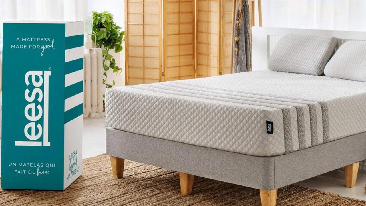 A box mattress from Leesa on a bed, next to the Leesa delivery box.