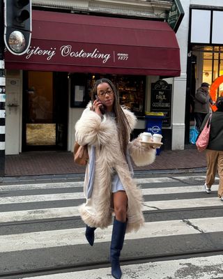 Woman wearing long coat with tall boots.