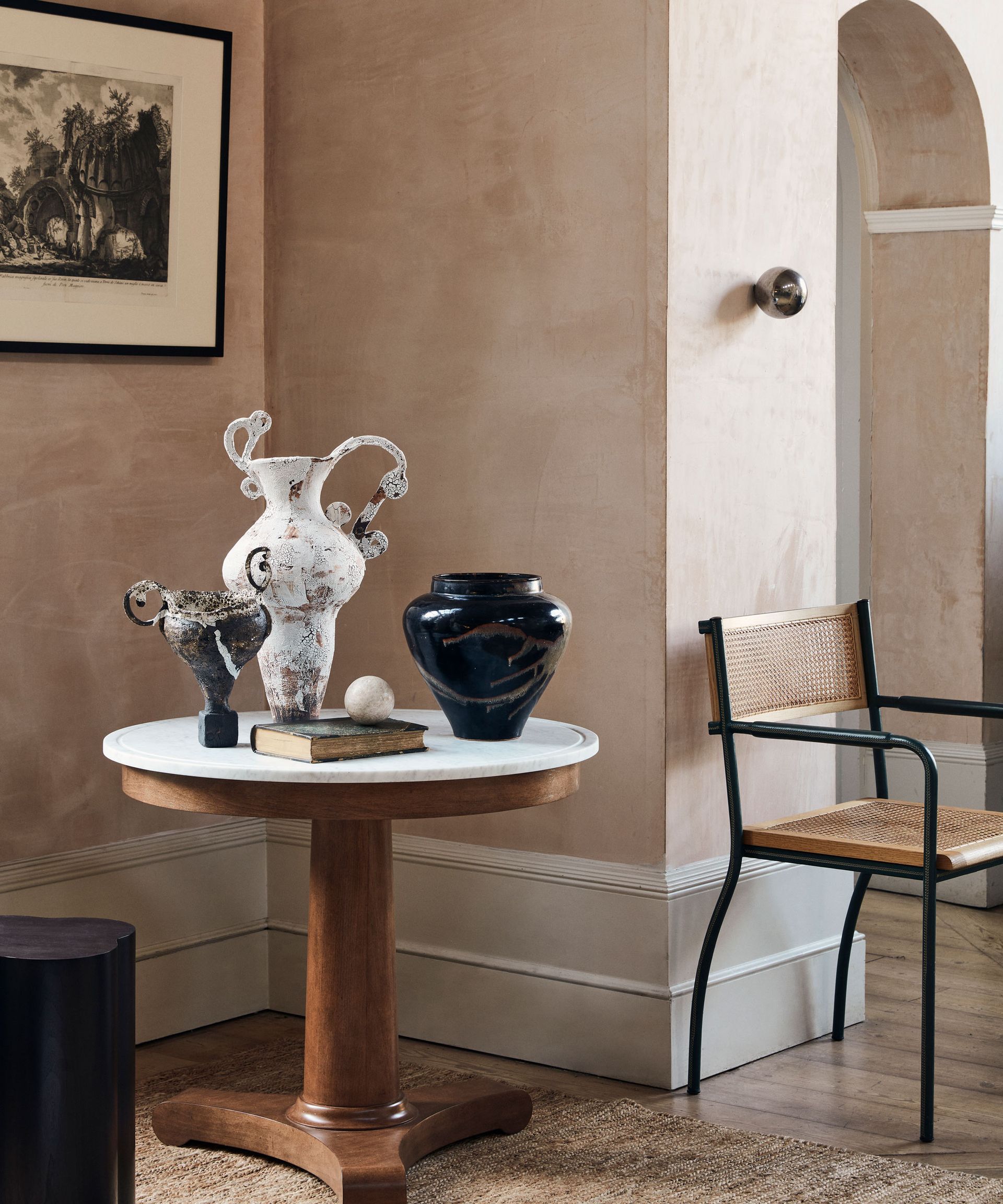 Classical round pedestal table with marble top as a corner display table for ceramic vessels