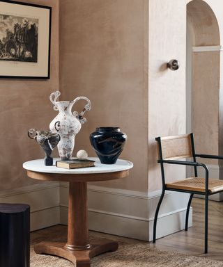 Classical round pedestal table with marble top as a corner display table for ceramic vessels