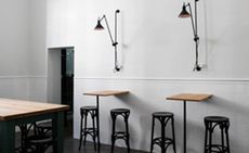 Surfboard tables with stools and overhead wall lamps