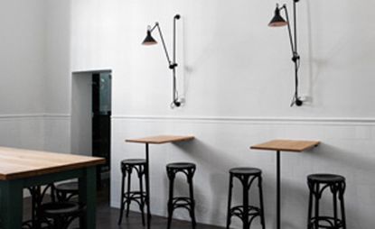 Surfboard tables with stools and overhead wall lamps