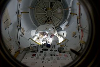 Halfway through the ISS airlock, Discovery shuttle astronaut Al Drew looks at the panorama for a second. This photo was taken by Italian astronaut Paolo Nespoli on the International Space Station on Feb. 28, 2011 during the first of two spacewalks for Dis