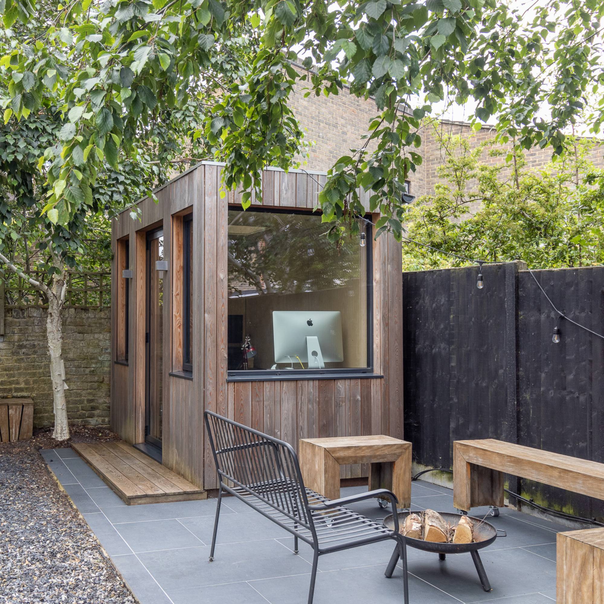 timber clad small garden room with outdoor patio area