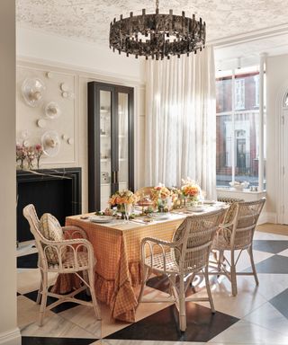 Traditional dining room setting with ornate ceiling plasterwork and black and white marble floor