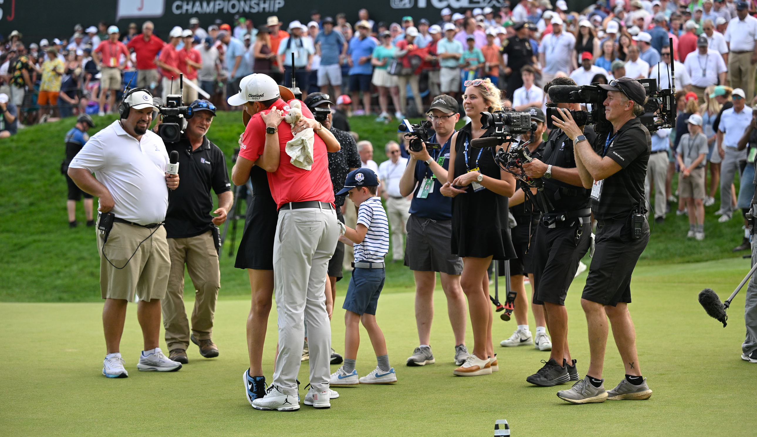 Keegan Bradley hugs his family on the 18th green at the Travelers Championship