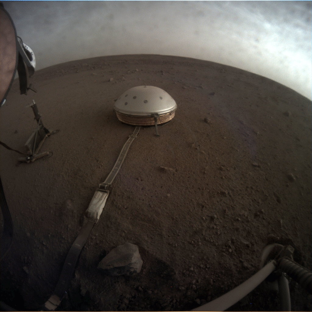 a metal dome lying on a red dusty patch of dirt