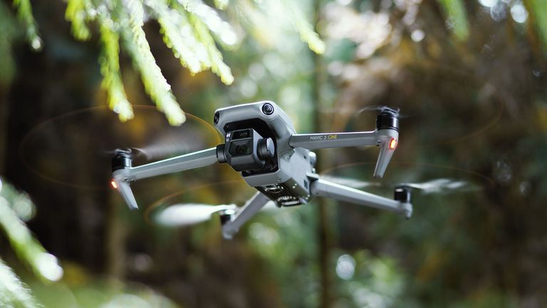 DJI Mavic 3 drone flying in a woodland