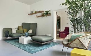 Lounge with green daybed and design seater with coffee table, single chair is corner