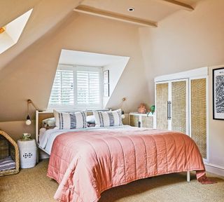 Peach bedroom with neutral carpet and deep coral throw on bed