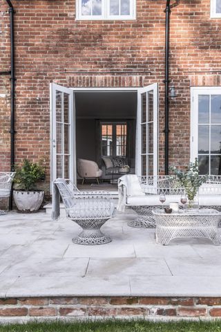 Patio area with paving, garden furniture and french doors outside a converted Victorian coachhouse