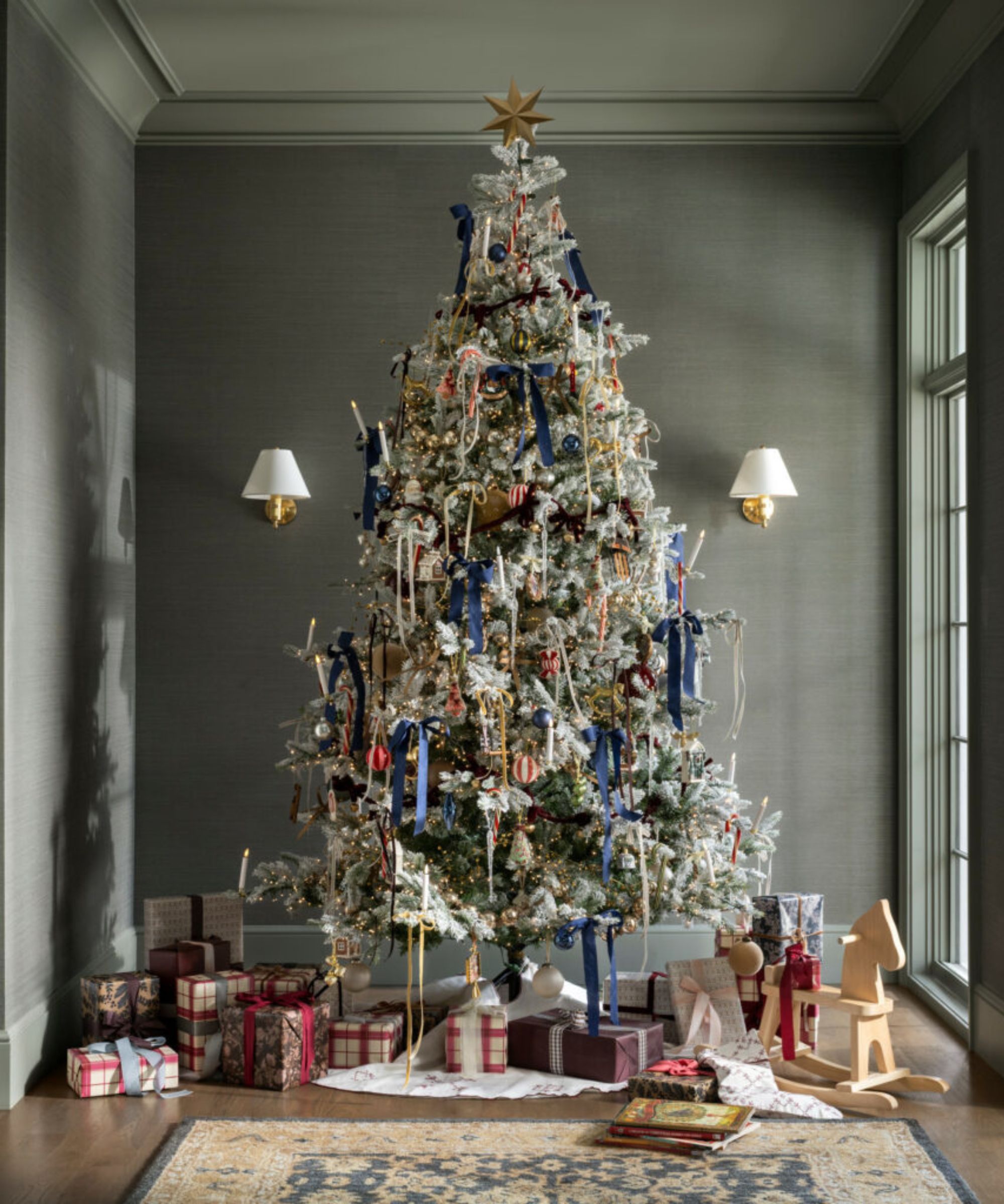 Christmas tree with ribbons and ornaments and a star topper surrounded by presents
