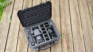 DJI Mavic 3T in open case with one spare battery on old wooden deck