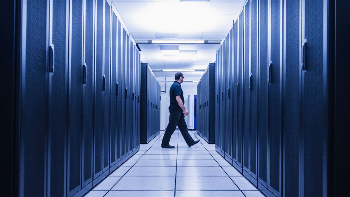 Man walking in aisle of server room