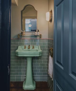 Bathroom with a light blue sink basin and mid blue wall tiles