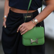 Elegant fitness trackers: A woman holding a handbag with an Oura Ring on