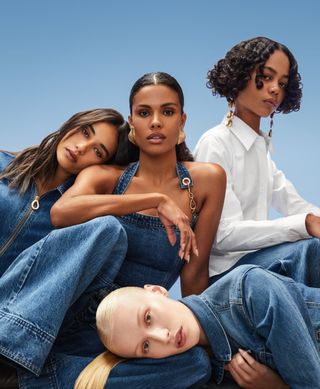 a group of four models wearing gap x cult gaia pieces in front of a blue backdrop