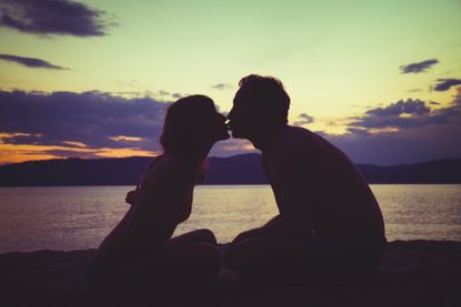 Couple kissing on beach.