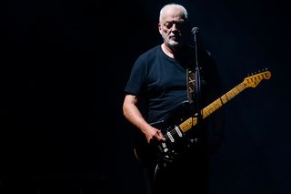 David Gilmour performs with his frequent companion—a black Fender Stratocaster.