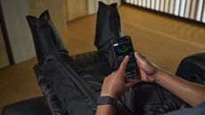 Person wearing the Helio Strap while using compression boots