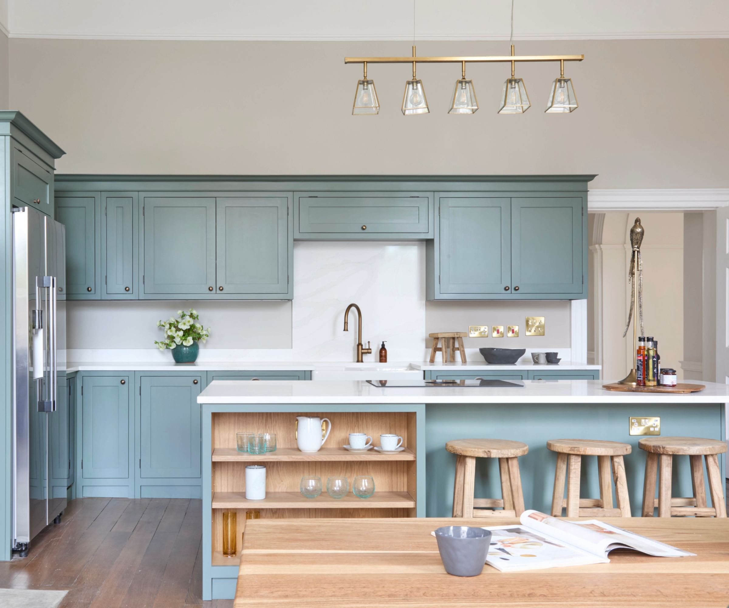 Blue kitchen with wooden stools, cupboard interior and table