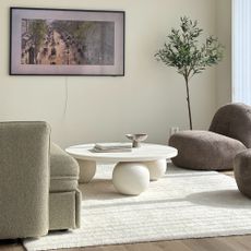 A minimalist living room with a DIY round coffee table with spherical legs painted white