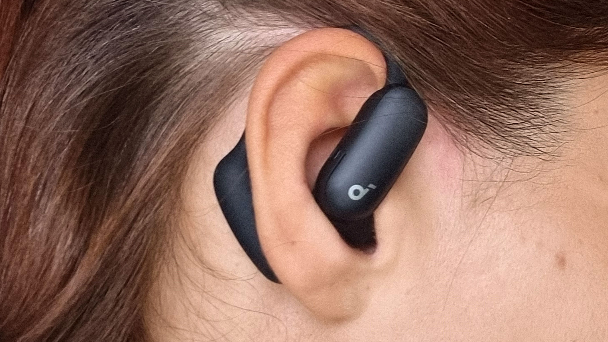 A close-up picture of our reviewer testing the Soundcore Aerofit 2 Pro earbuds